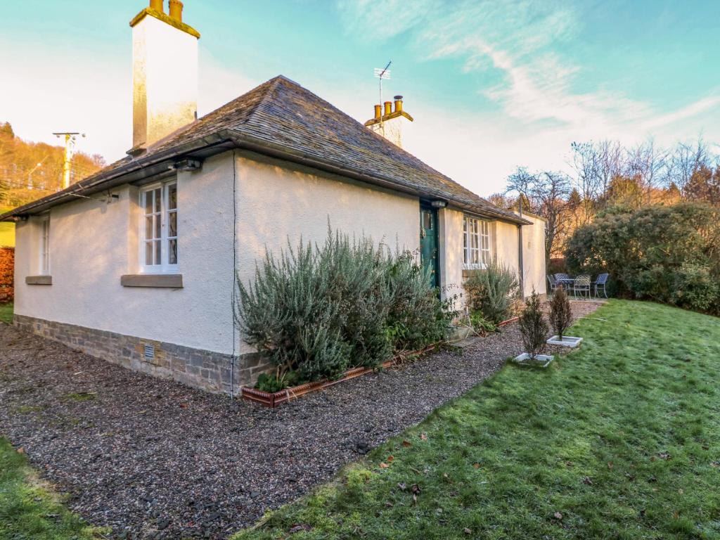 a small white house with plants in the yard at East Cottage - Tarvit in Cupar