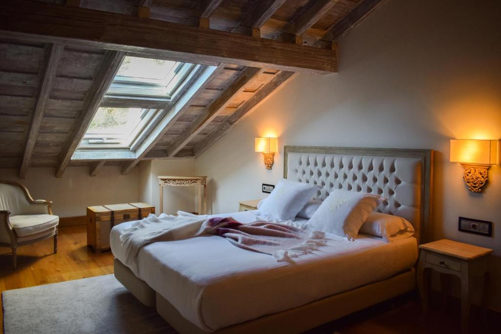 a bedroom with a large white bed with a skylight at Casona De La Pinta in Ríocorvo