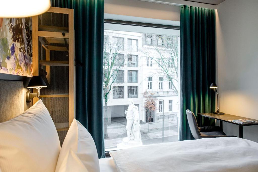 アントワープにあるMotel One Antwerpのベッドと大きな窓があるホテルの部屋