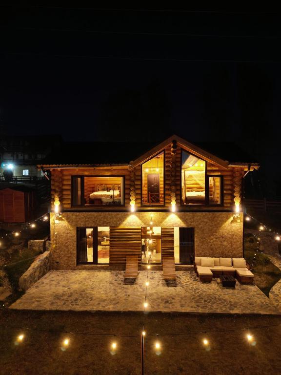 a house with lights in front of it at night at MaviLand Chalet in Bran