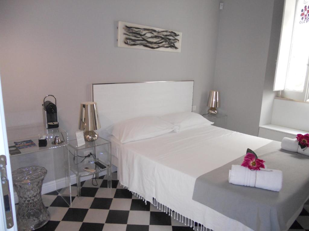 a bedroom with a white bed and a checkered floor at Arco' B&B in Trani