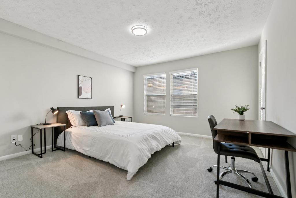 a white bedroom with a bed and a desk at Halsten At Vinings 2106 Spacious 2bd 15 Bth in Atlanta