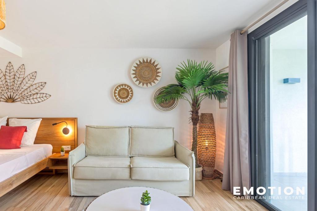 a living room with a bed and a chair at Studio Alamanda Baie Orientale in Orient Bay