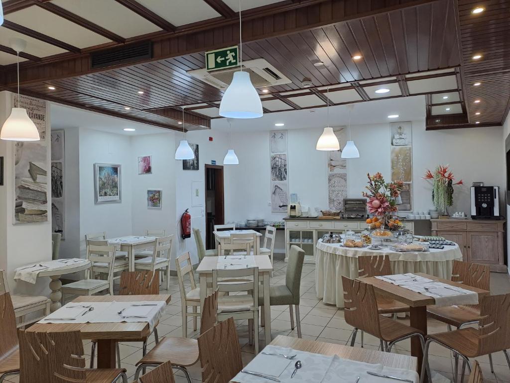 ein Restaurant mit Tischen und Stühlen und eine Küche in der Unterkunft Hotel SQUARE in Sertã