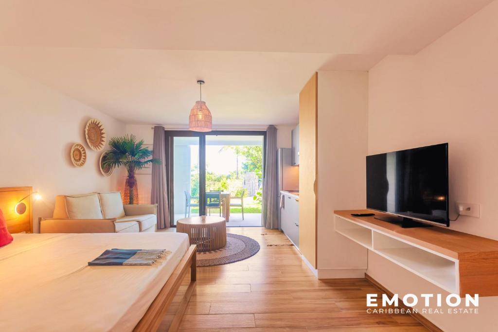a living room with a television and a couch at Studio Alamanda Baie Orientale in Orient Bay