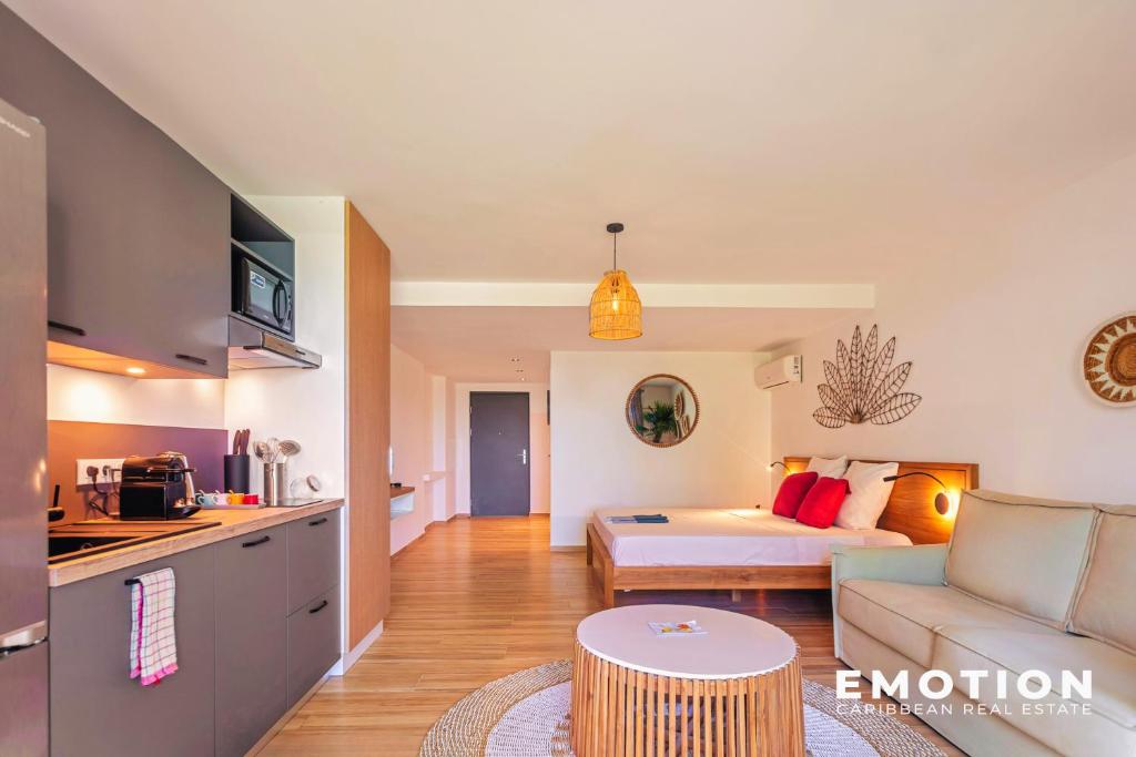 a living room with a couch and a bed at Studio Alamanda Baie Orientale in Orient Bay