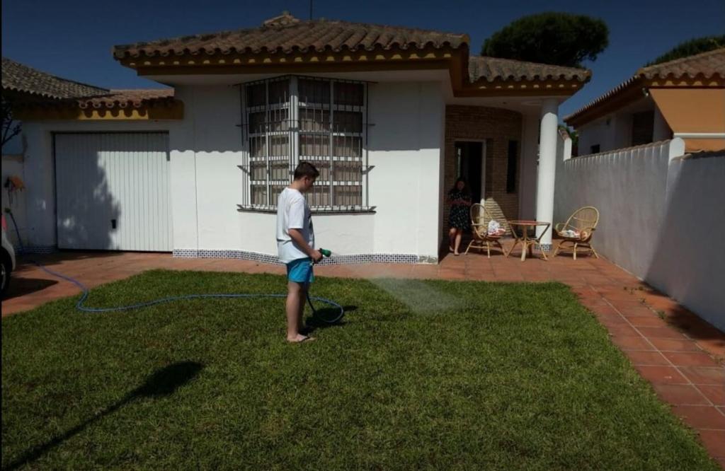 a man standing in a yard in front of a house at Santa Ana in Novo Sancti Petri
