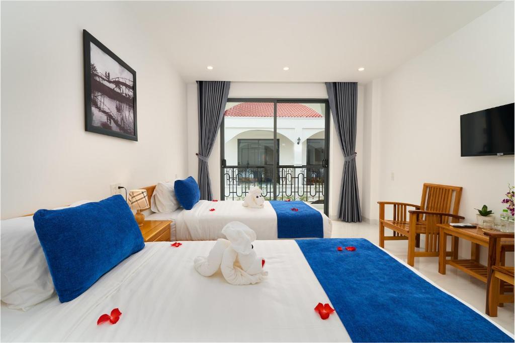 Postel nebo postele na pokoji v ubytování Hoi An Legend Charm Boutique Hoi An Hotel