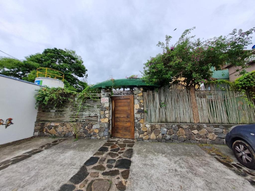 a stone building with a door and a fence at Recanto de Gaia in Ilhabela
