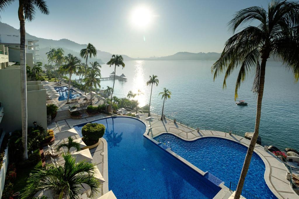 a swimming pool with a view of the water at Camino Real Acapulco Diamante in Acapulco
