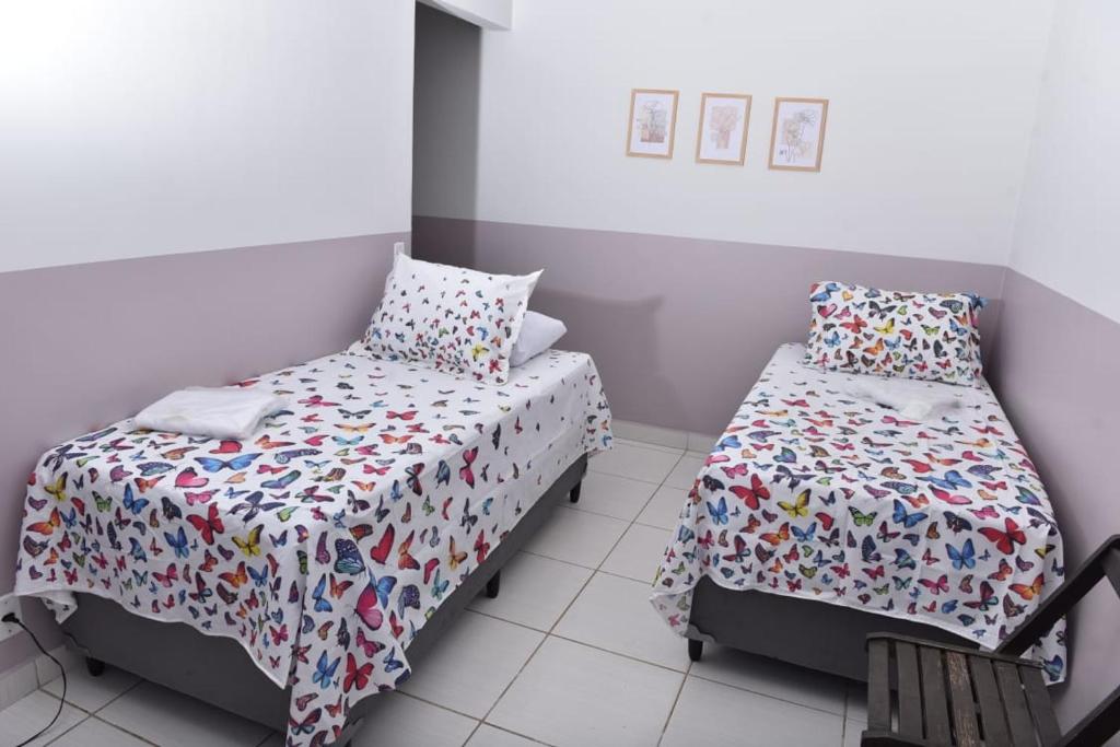 a bedroom with two beds and a bedspread with shoes at Casa da Vó Maria 10 in Goiânia