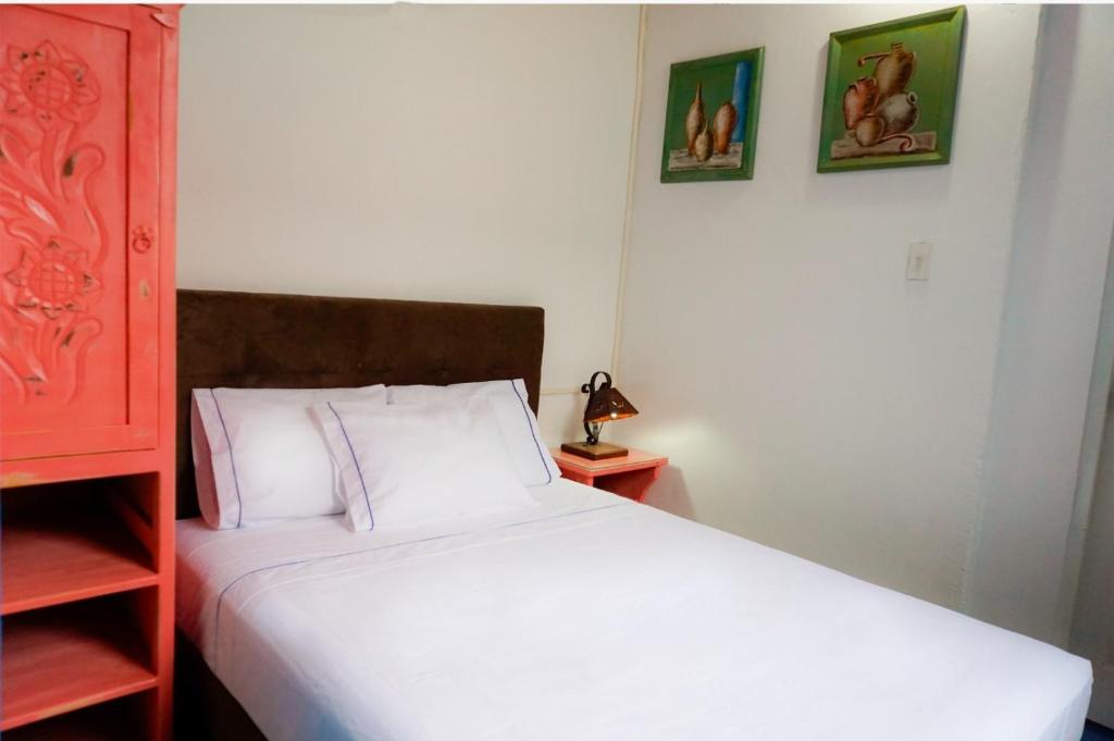 a bedroom with a bed and two pictures on the wall at Hotel casa Narvaez in Girardot