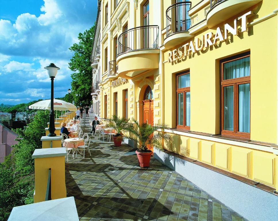 un edificio amarillo con un cartel en el costado en Wellness Hotel Jean De Carro, en Karlovy Vary