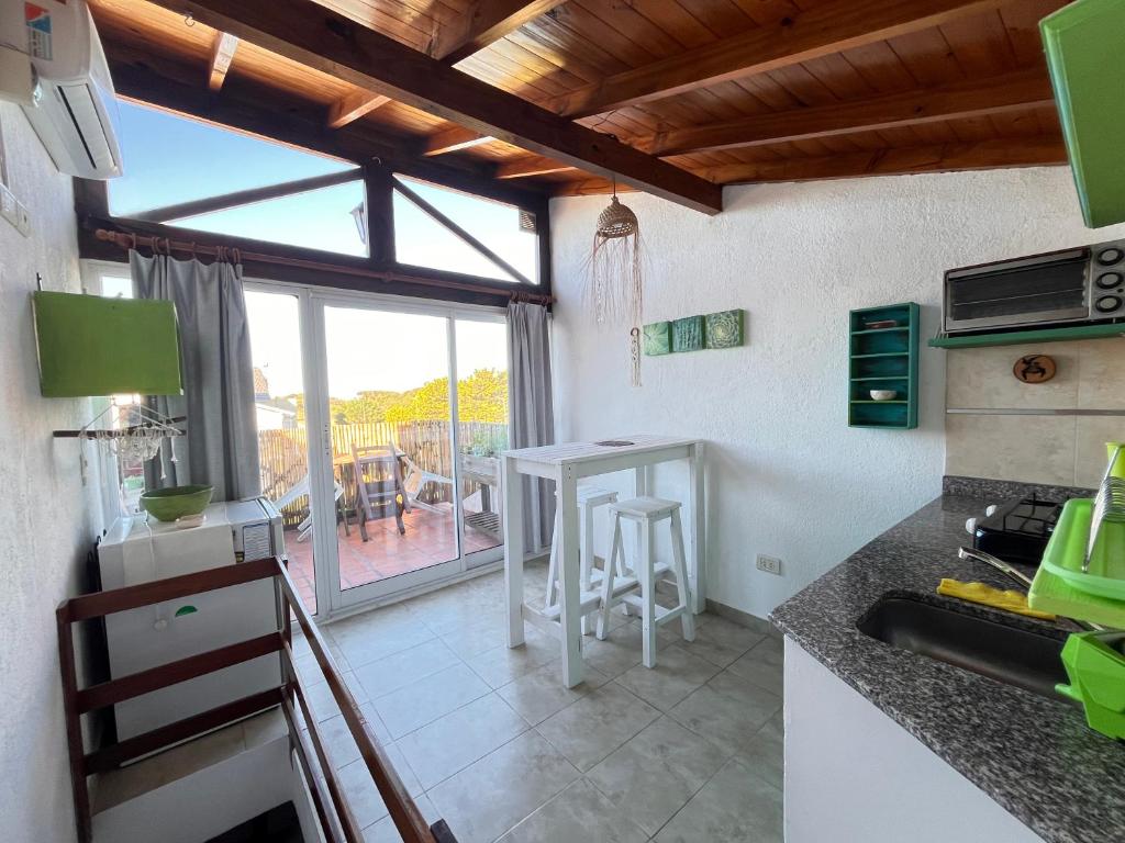 een keuken met een tafel en uitzicht op een patio bij Complejo Noi Alaia in Valeria del Mar