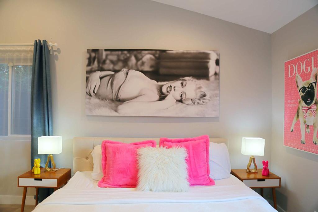 een slaapkamer met een bed met roze kussens bij Casa Marilyn in Palm Springs
