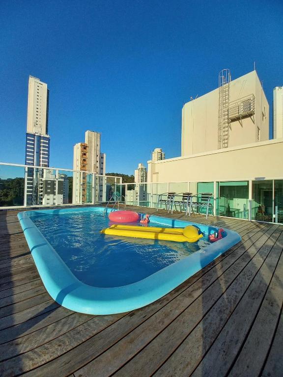 a pool on the roof of a building at QE01- Studio| Jacuzzi Aquecida| Piscina| Churrasq. in Cabeçudas