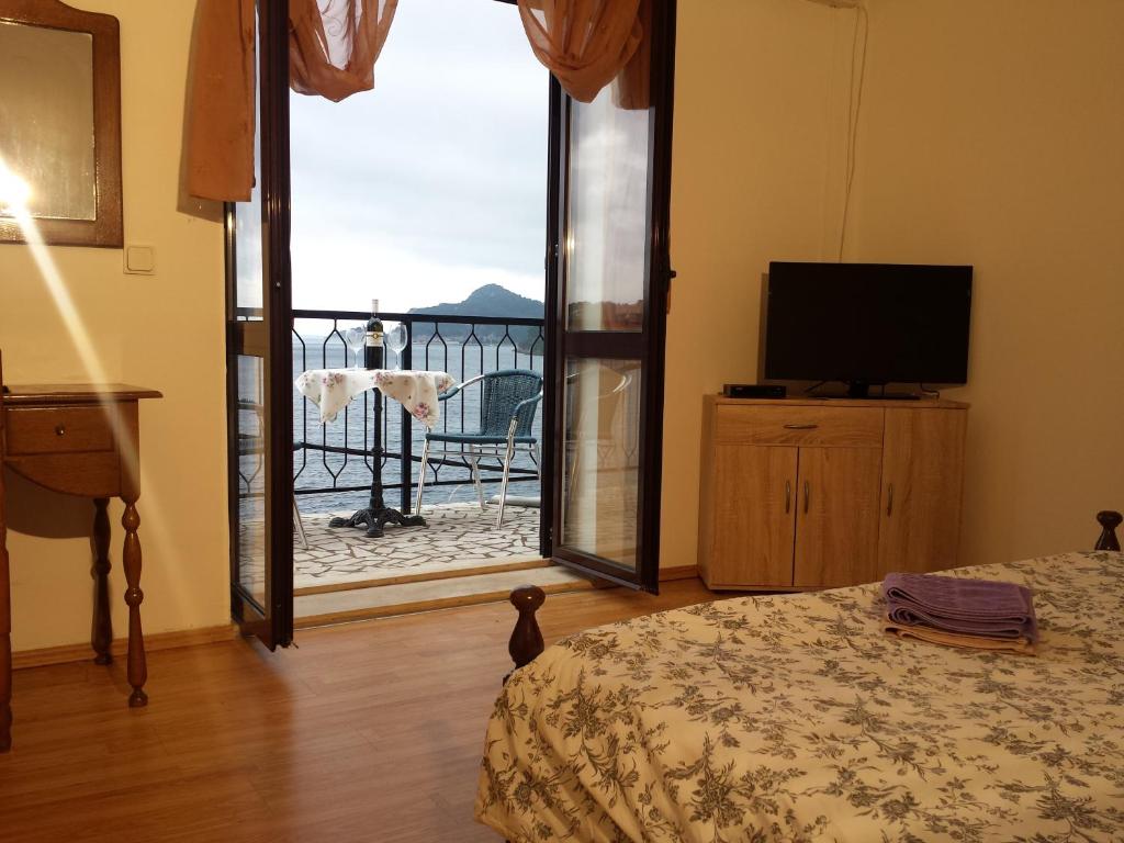 Pokój z łóżkiem, telewizorem i oknem w obiekcie Apartments "Villa Mungos" Sobra w mieście Sobra