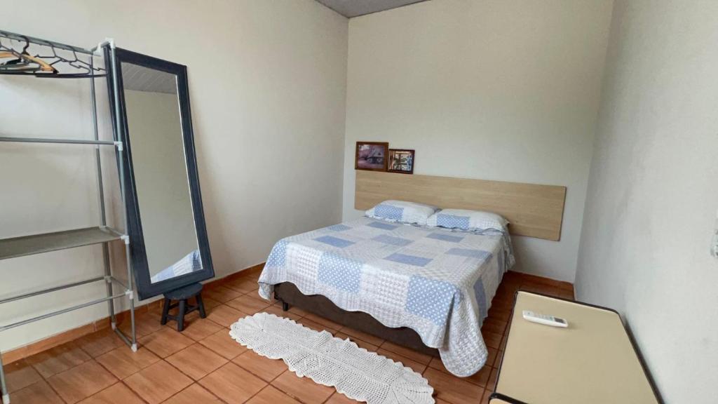 a small bedroom with a bed and a mirror at Casa próxima ao Centro de Foz in Foz do Iguaçu