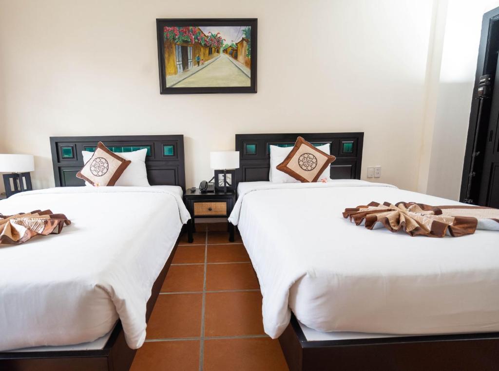 Postel nebo postele na pokoji v ubytování Nature Resort Hoi An By K D H