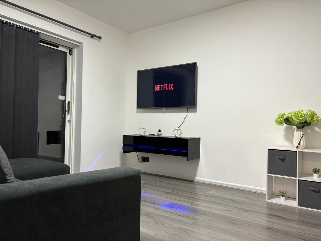 ein Wohnzimmer mit einem Sofa und einem Fernseher an der Wand in der Unterkunft 2-Bed House by Knighthead Park w- FREE Parking & FREE MATCHDAY DROP-OFF in Birmingham