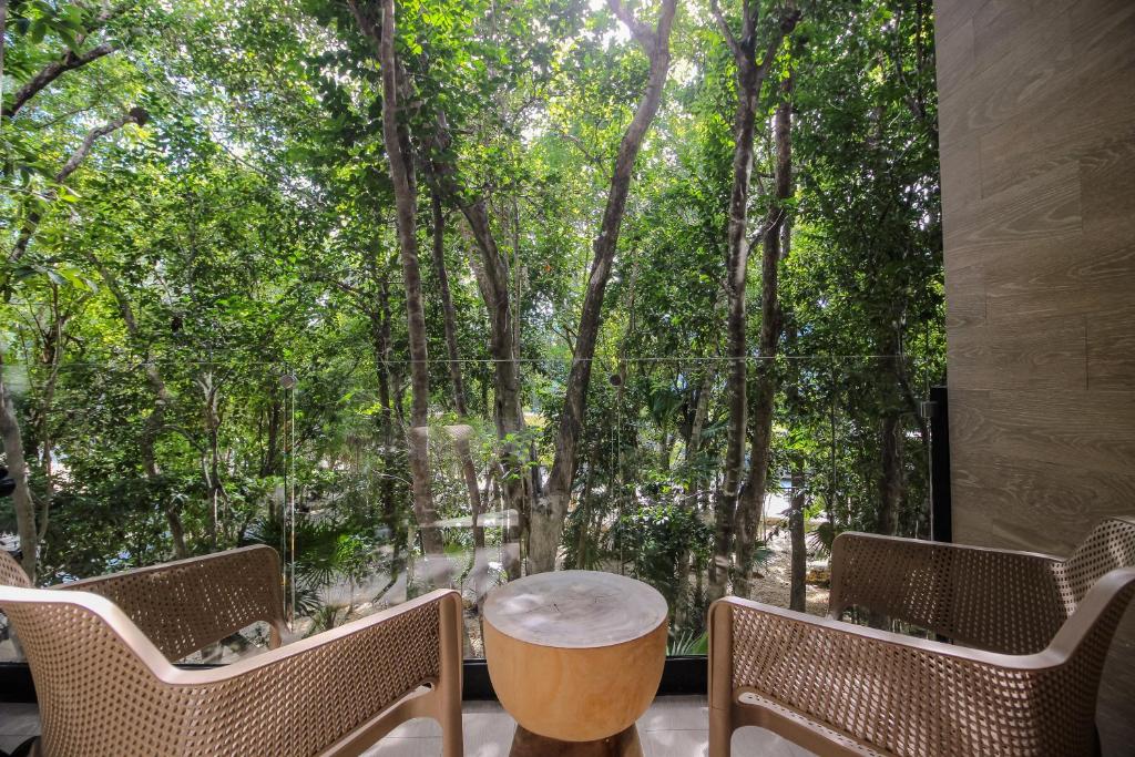 a room with a table and chairs and trees at Luxury Studio with Rooftop Pool and Gym in Top Location in Tulum