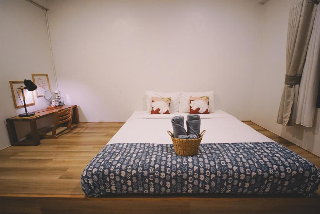 a bedroom with a bed with a basket on it at Sleepy House Chiang Rai in Chiang Rai