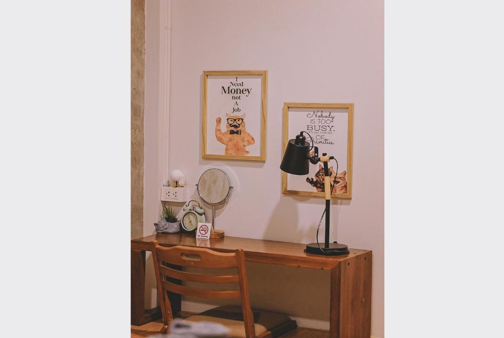 a desk with a mirror and a lamp on it at Sleepy House Chiang Rai in Chiang Rai