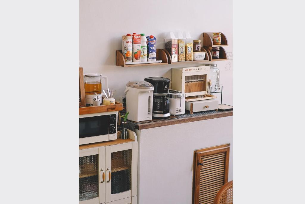 a kitchen with several appliances on a counter at Sleepy House Chiang Rai in Chiang Rai