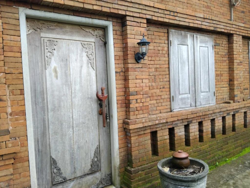 a brick house with a door and a window at Puri kahuripan in Kediri