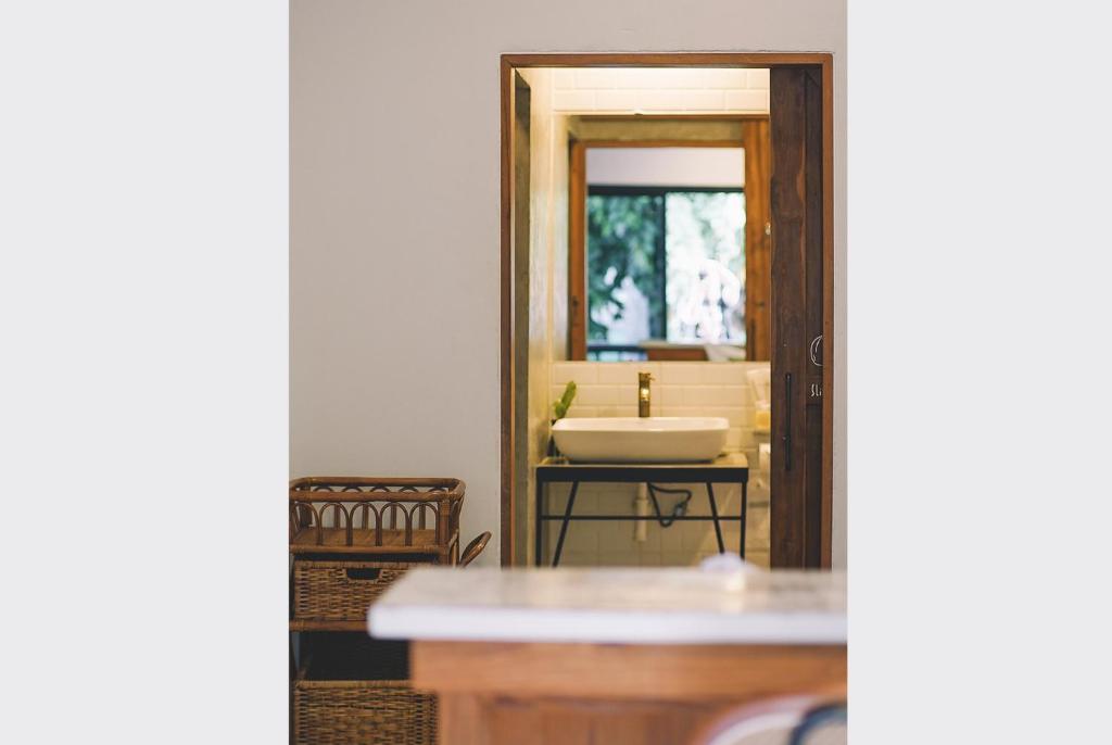 a bathroom with a sink and a mirror at Sleepy House Chiang Rai in Chiang Rai