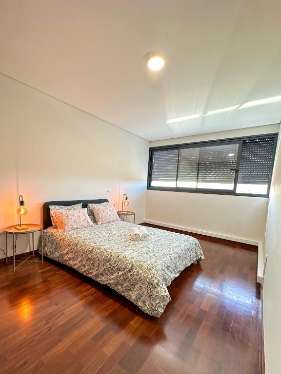 a bedroom with a bed and a large window at Espinho in São Félix da Marinha