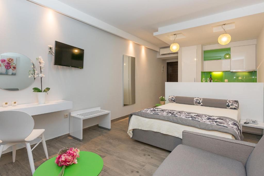 Dormitorio blanco con cama y mesa en Mary's Luxury, en Chrysi Ammoudia