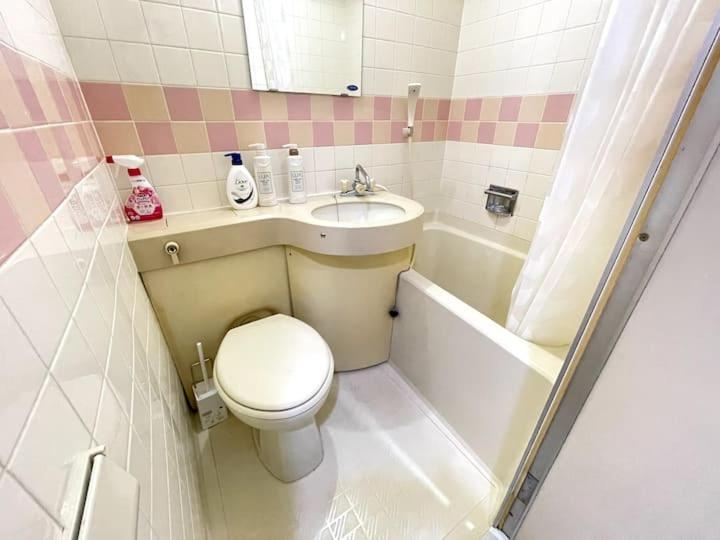 a small bathroom with a toilet and a sink at Shinjuku宿 in Tokyo