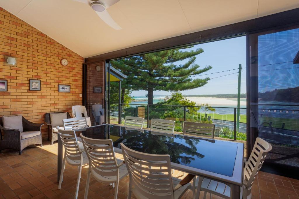 a room with a table and chairs and a large window at Peninsula in Sawtell