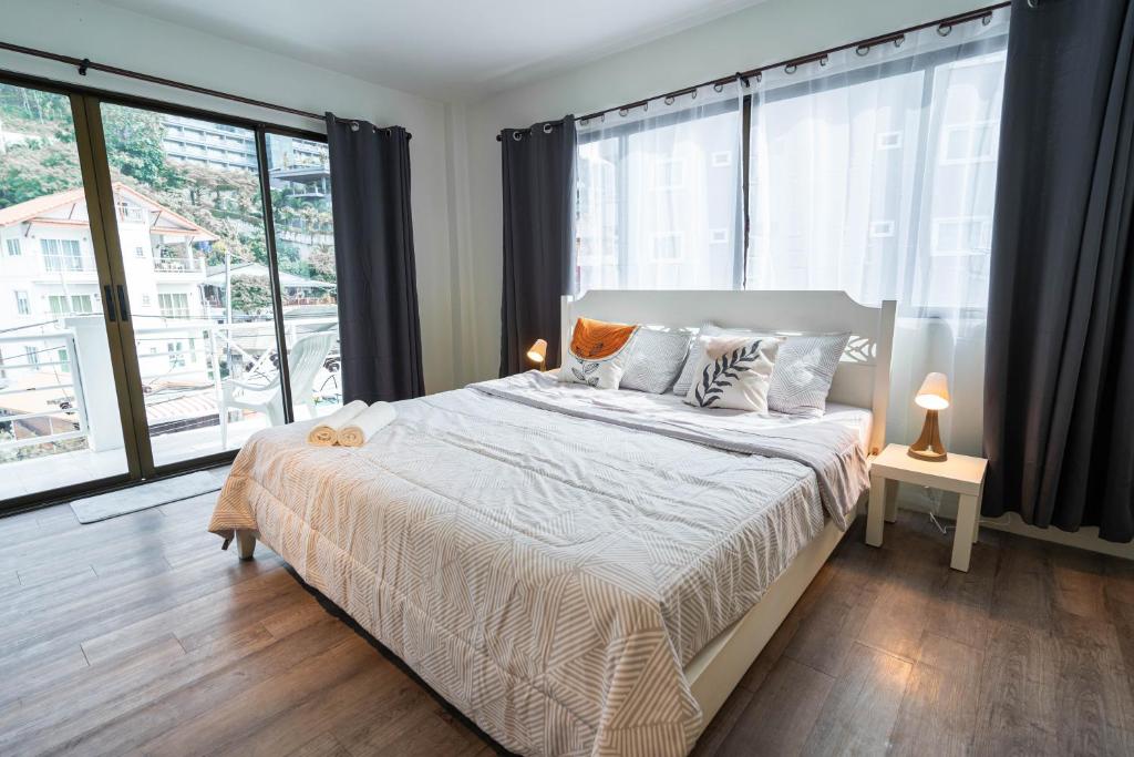 a bedroom with a bed and a large window at Patong Center Comfort Stay in Patong Beach