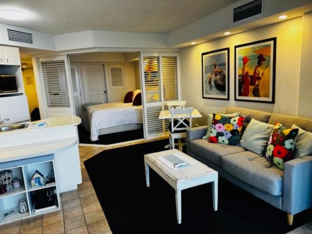 ein Wohnzimmer mit Sofa und Bett in der Unterkunft Five o clock somewhere in Golden Beach