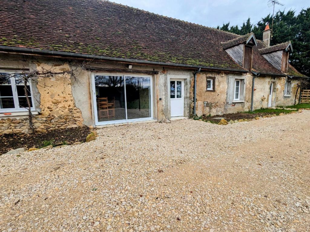 une vieille maison en pierre avec une grande allée devant elle dans l'établissement Maison familiale rénovée dans village médiéval - FR-1-591-712, à Levroux
