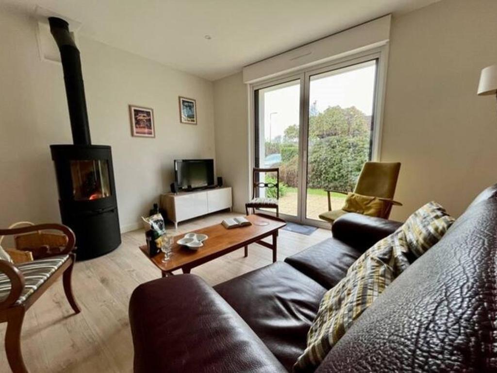 un salon avec un canapé et une cheminée dans l'établissement Maison rénovée à Fouesnant, proche plages, jardin et terrasse - FR-1-481-167, à Fouesnant