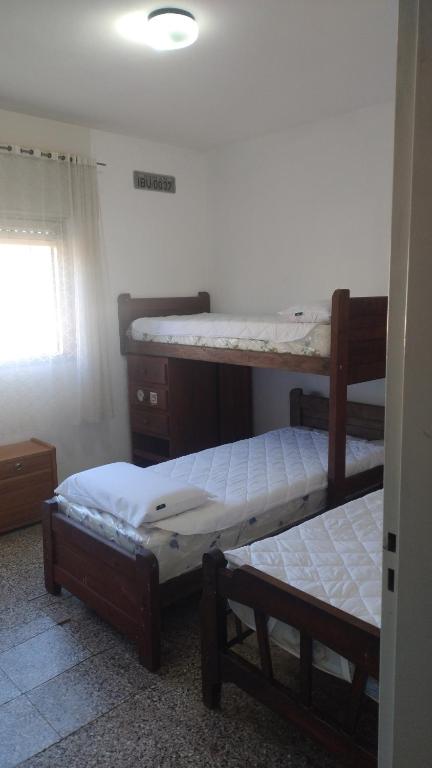 a room with three bunk beds and a window at Casa hasta 5 personas in Villa Carlos Paz