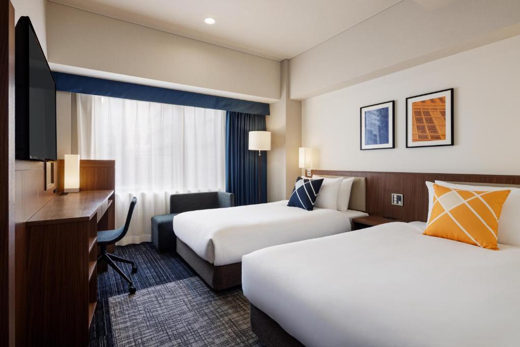Postel nebo postele na pokoji v ubytování Four Points Flex by Sheraton Osaka Shinsaibashi