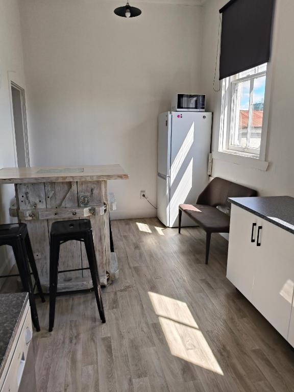 kuchnia z drewnianym stołem i lodówką w obiekcie Apartment In Nelson CBD Hospitality Zone w mieście Nelson