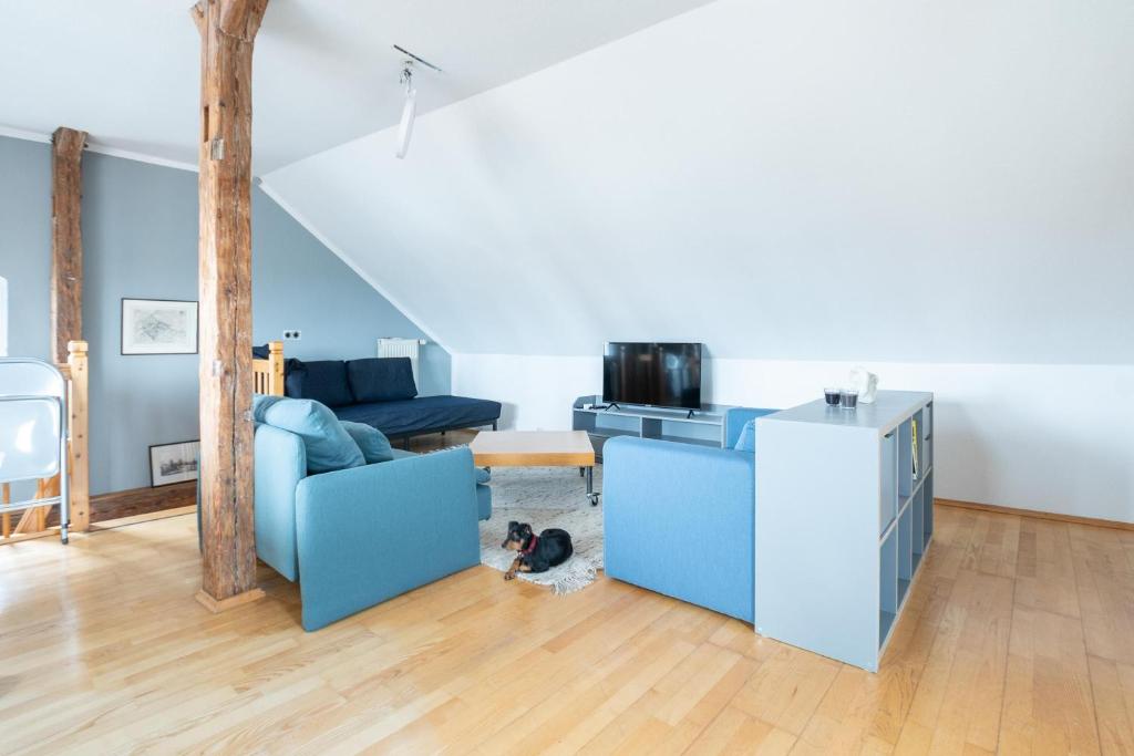 a living room with a blue couch and a dog at Dohna, App 116 in Pirna