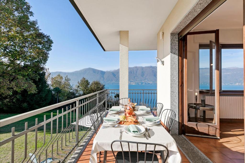a table on a balcony with a view of the water at Casa Antonia - Happy Rentals in Porto Valtravaglia