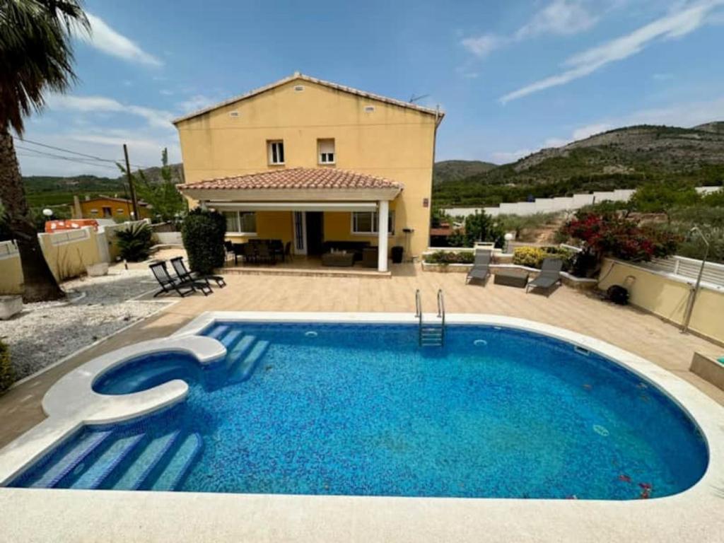 a large blue swimming pool in front of a house at Chalet Borriol Golf REF 028 in Borriol