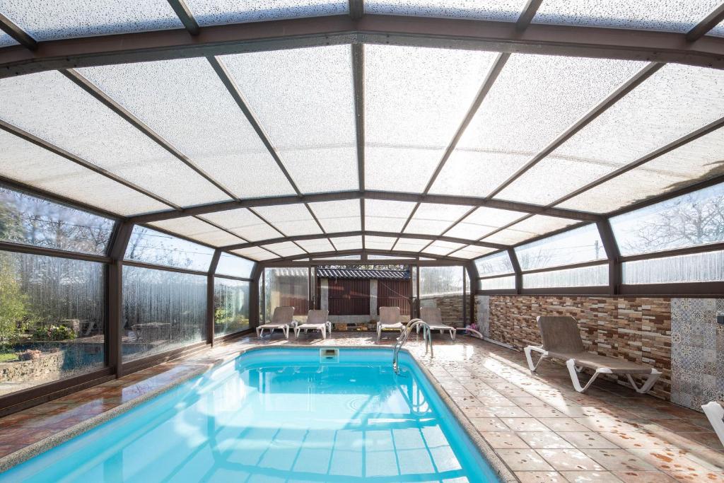 ein Hallenbad mit Glasdach und Hallenbadvisier in der Unterkunft O forno do curro-Casiña Da Avelá in Boborás