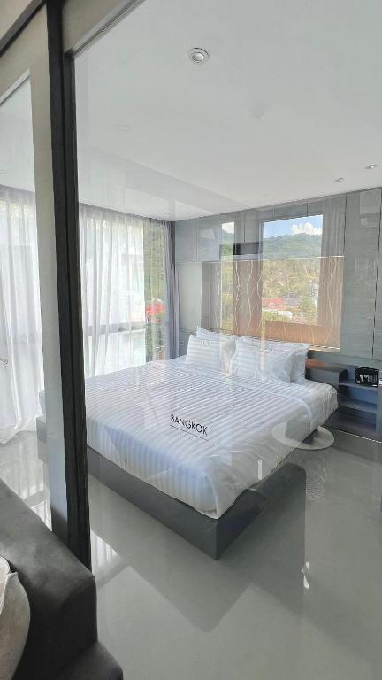 a large bed in a room with a window at AdWords Mountain View CityGate Kamala in Phuket