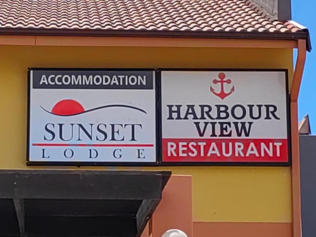 two signs on the side of a building at Sunset Lodge in St. Helena Bay