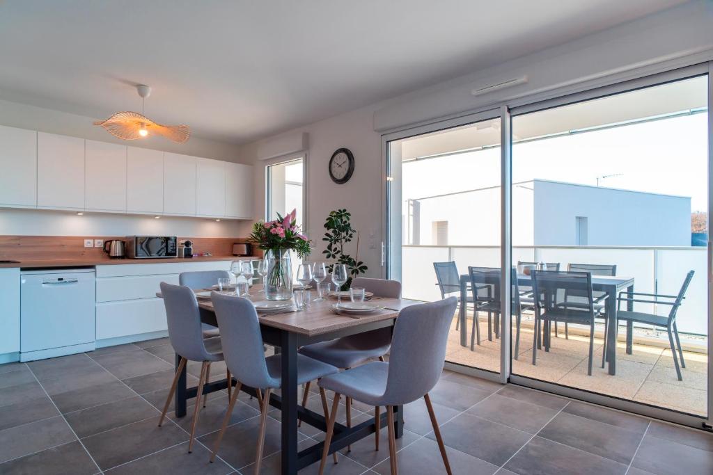 eine Küche und ein Esszimmer mit Tisch und Stühlen in der Unterkunft Le Jardin du Golfe - En centre-ville avec parking in Sarzeau