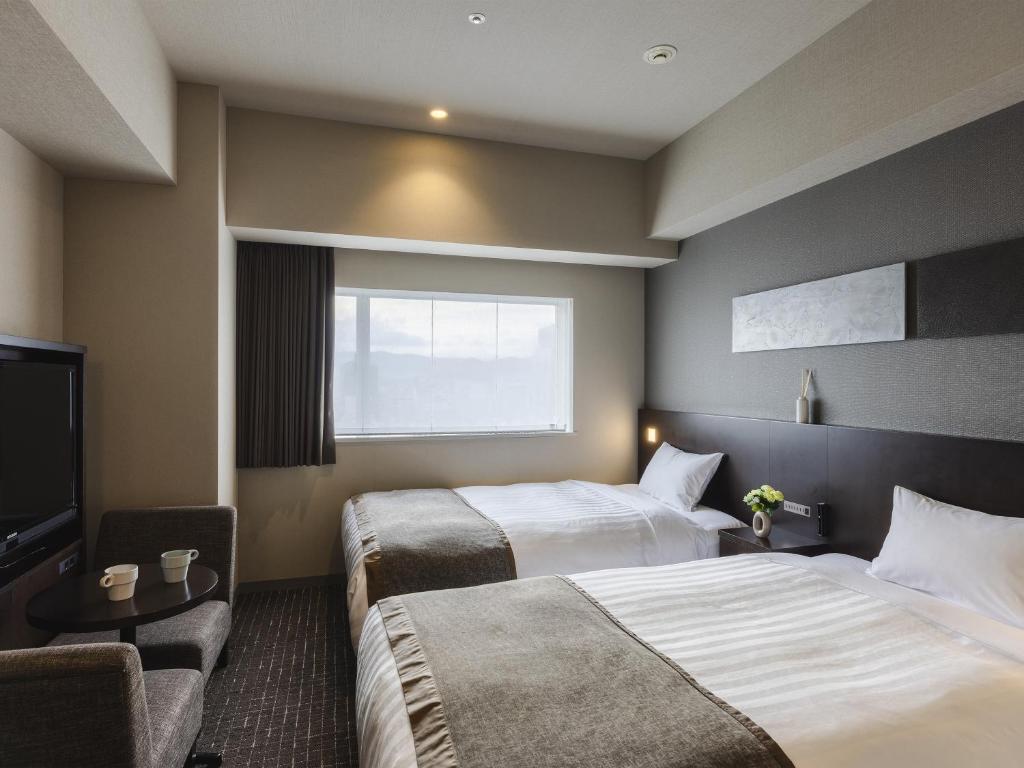 Postel nebo postele na pokoji v ubytování Hiroshima Washington Hotel