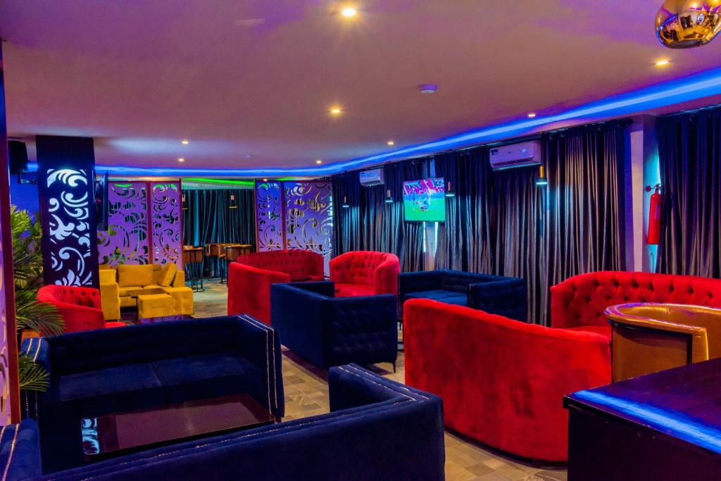 una camera con sedie rosse e blu e una TV di House10 luxury hotel and suites a Lagos